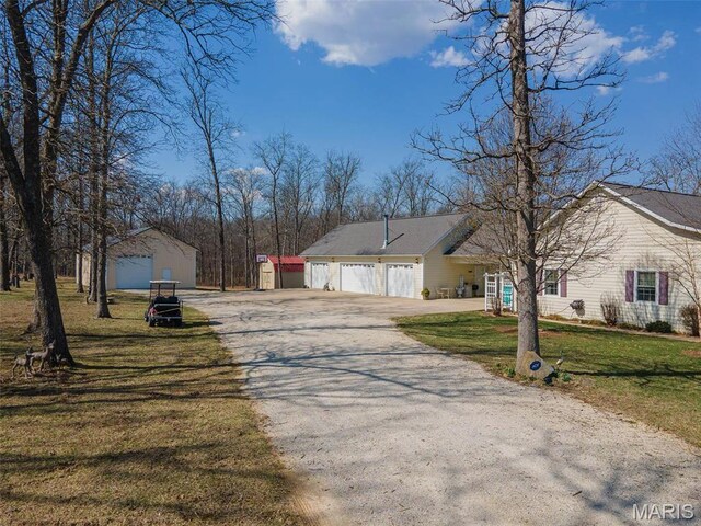 17205 Elk Prairie Dr, Rolla, MO 65401 - view of front of property with asphalt driveway, a front lawn, an attached garage, and an outdoor structure