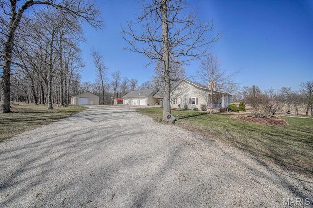 17205 Elk Prairie Dr, Rolla, MO 65401 - view of front facade with a garage, a front yard, an outdoor structure, and gravel driveway