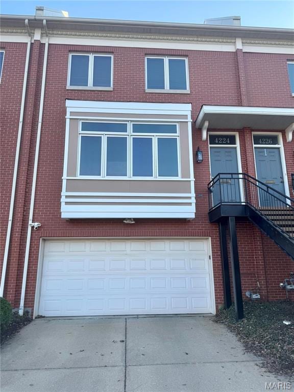 4224 Laclede Ave Unit C, Saint Louis, MO 63108 - view of property featuring a garage, driveway, and brick siding