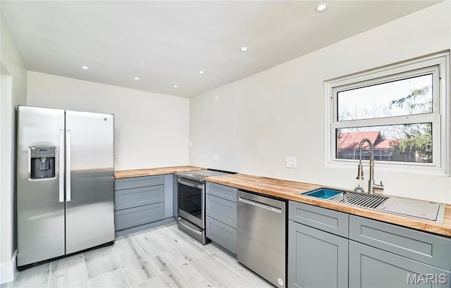 601 Brotherton Ln, Saint Louis, MO 63135 - kitchen featuring appliances with stainless steel finishes, butcher block counters, gray cabinetry, and recessed lighting