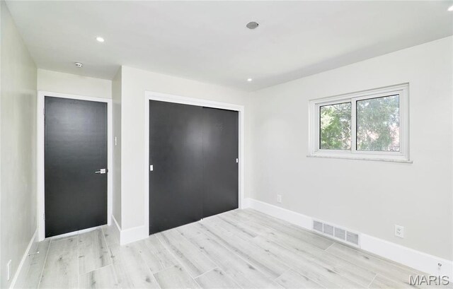 601 Brotherton Ln, Saint Louis, MO 63135 - unfurnished bedroom with wood finished floors, a closet, baseboards, and recessed lighting