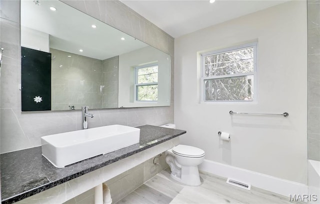 601 Brotherton Ln, Saint Louis, MO 63135 - bathroom with a sink, toilet, tasteful backsplash, recessed lighting, and baseboards