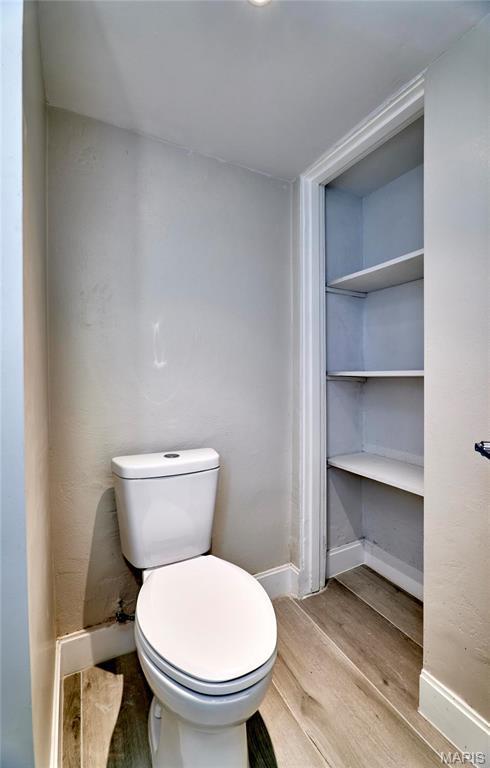 601 Brotherton Ln, Saint Louis, MO 63135 - bathroom featuring wood finished floors, toilet, and baseboards