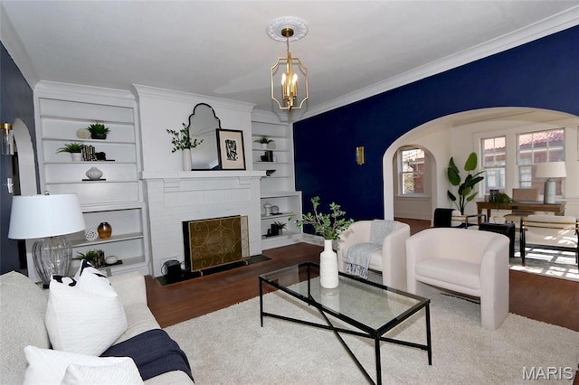 3092 Bellerive Dr, Saint Louis, MO 63121 - living area featuring arched walkways, wood finished floors, crown molding, built in features, and a chandelier
