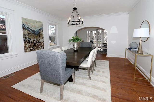 3092 Bellerive Dr, Saint Louis, MO 63121 - dining room featuring arched walkways, a chandelier, ornamental molding, baseboards, and wood finished floors
