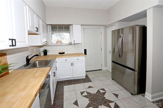 3092 Bellerive Dr, Saint Louis, MO 63121 - kitchen featuring stainless steel appliances, butcher block countertops, a sink, and decorative backsplash