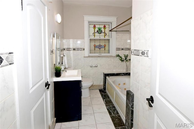 3092 Bellerive Dr, Saint Louis, MO 63121 - bathroom featuring tile walls, a whirlpool tub, vanity, marble look tiles, and toilet