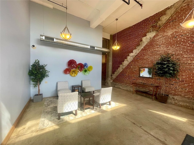 lobby with a high ceiling and brick wall