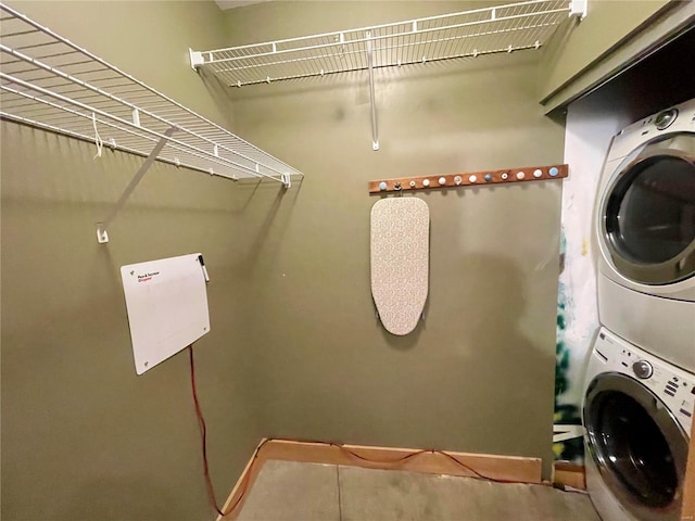 washroom featuring stacked washer and clothes dryer