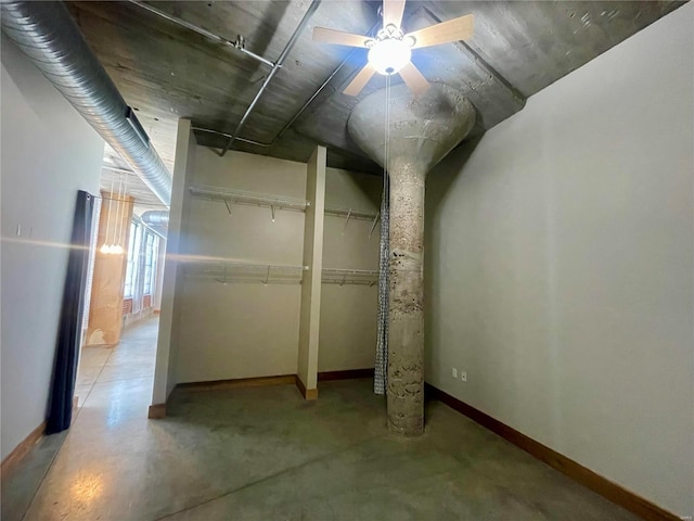 below grade area with baseboards and ceiling fan