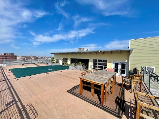 view of swimming pool with french doors, outdoor dining area, and fence