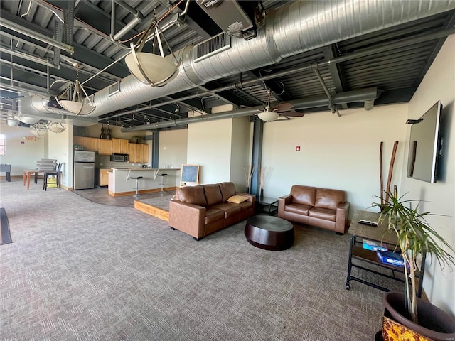 below grade area featuring freestanding refrigerator and carpet floors