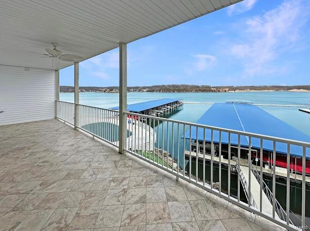 balcony featuring a water view and ceiling fan