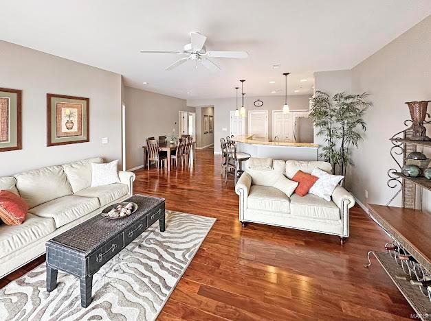 living area with a ceiling fan and wood finished floors