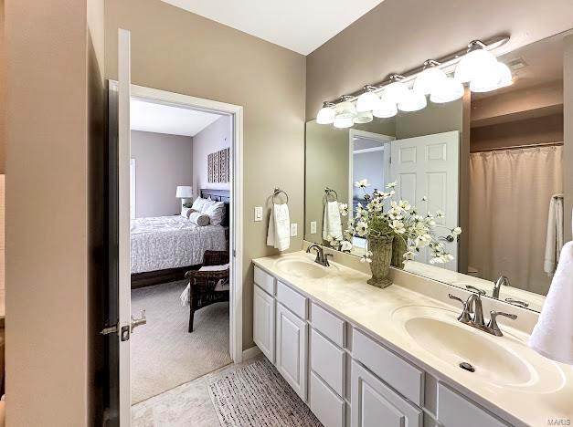 bathroom with double vanity and ensuite bath