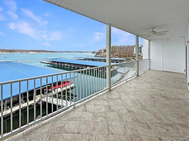 balcony with a water view and a ceiling fan