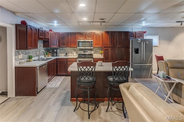 424 N College St, Centralia, IL 62801 - kitchen featuring stainless steel appliances, light countertops, light wood-style floors, a center island, and a breakfast bar area