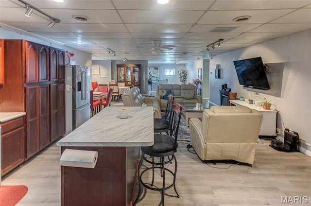 424 N College St, Centralia, IL 62801 - kitchen with high end fridge, a kitchen bar, open floor plan, ceiling fan, and light wood-type flooring