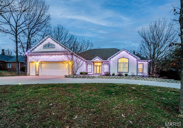 view of front facade featuring an attached garage, a front yard, and driveway