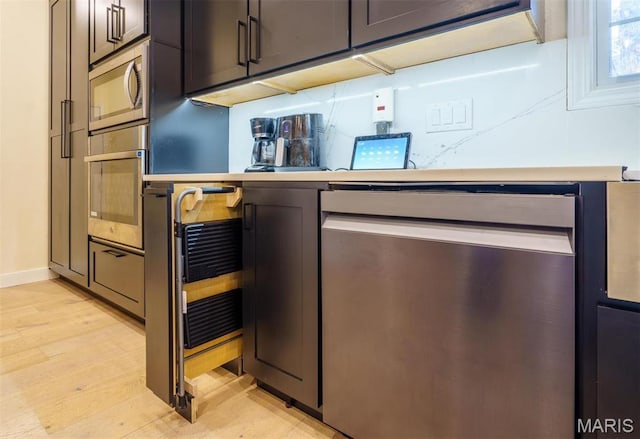 bar area with appliances with stainless steel finishes, light wood-style flooring, and baseboards