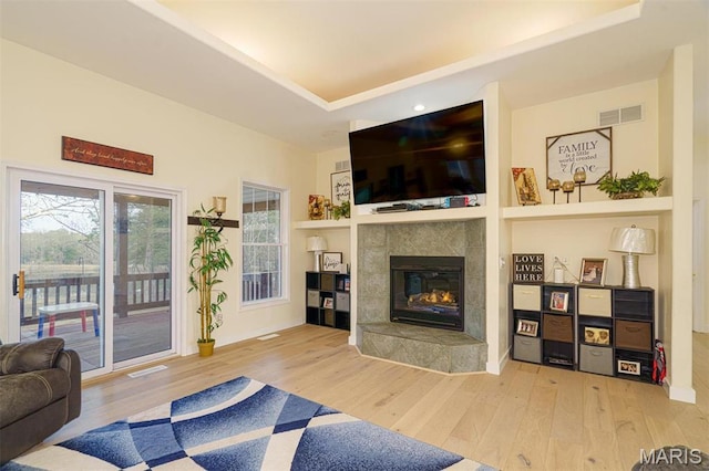 living area featuring wood finished floors and a tiled fireplace