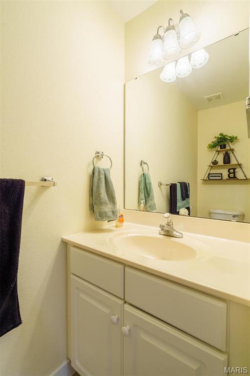 half bathroom with vanity and toilet