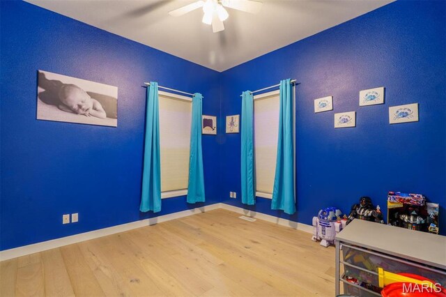 unfurnished bedroom with wood finished floors, baseboards, and ceiling fan