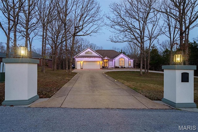 view of front of property featuring a garage, concrete driveway, and a front lawn