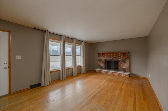 762 Cave Farm Rd, Troy, MO 63379 - unfurnished living room featuring light wood-style flooring, a brick fireplace, and baseboards