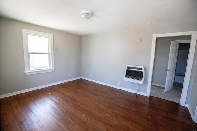 unfurnished living room featuring heating unit, dark wood-style flooring, and baseboards