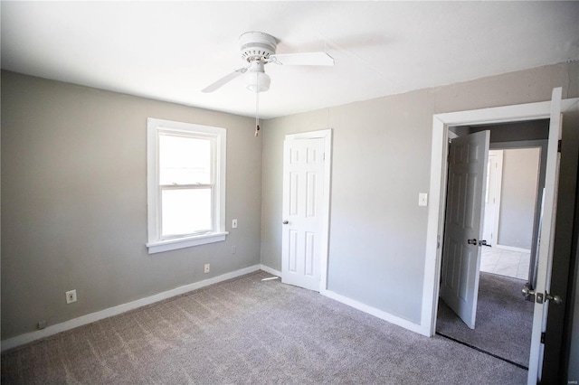 unfurnished bedroom with carpet, baseboards, a closet, and ceiling fan