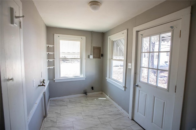 entryway featuring light marble finish floors and baseboards