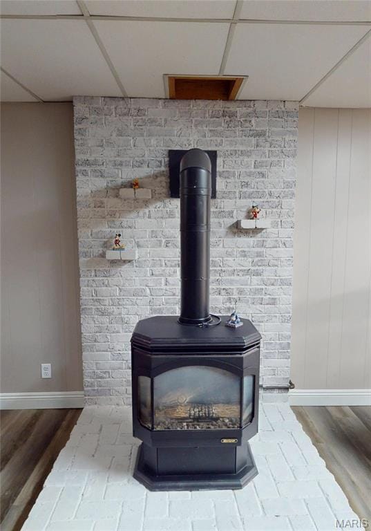 20 Denzel Dr, Greenville, IL 62246 - detailed view of a wood stove, a paneled ceiling, wood finished floors, and baseboards