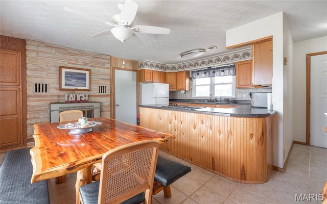 24265 Vinyard Rd, Cuba, MO 65453 - kitchen with freestanding refrigerator, a ceiling fan, dark countertops, gas stovetop, and a peninsula