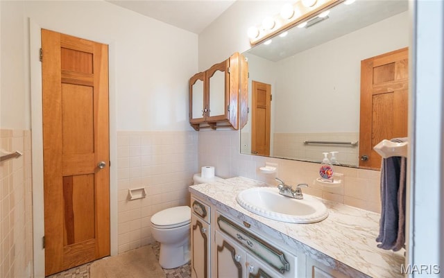 24265 Vinyard Rd, Cuba, MO 65453 - bathroom featuring tile walls, vanity, wainscoting, toilet, and tile patterned floors