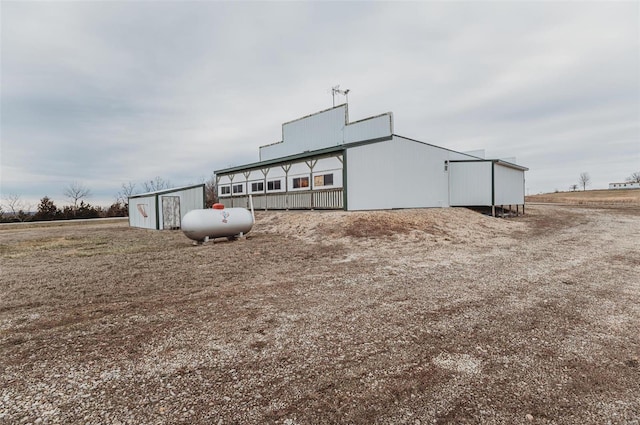 rear view of property with an outbuilding and a pole building