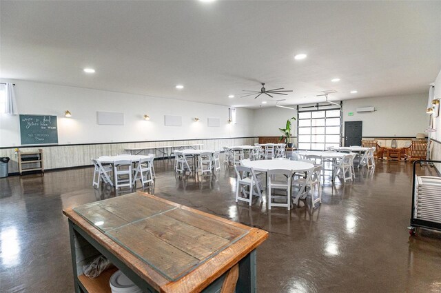 dining space with concrete floors, ceiling fan, recessed lighting, and an AC wall unit