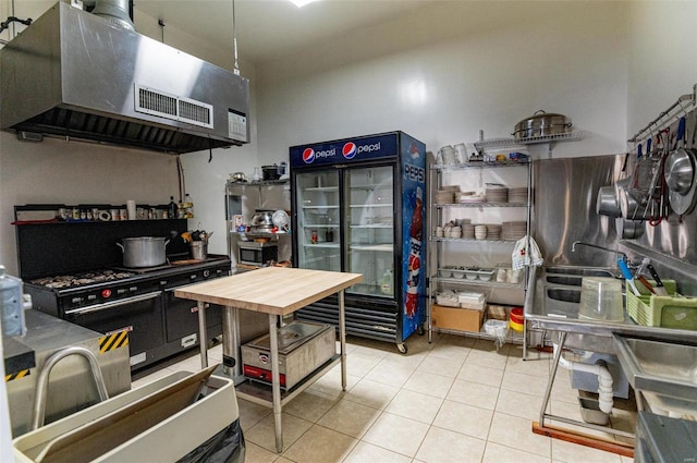 kitchen featuring range with two ovens, range hood, and tile patterned flooring