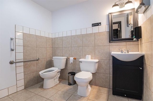 bathroom featuring toilet, tile walls, tile patterned floors, and vanity