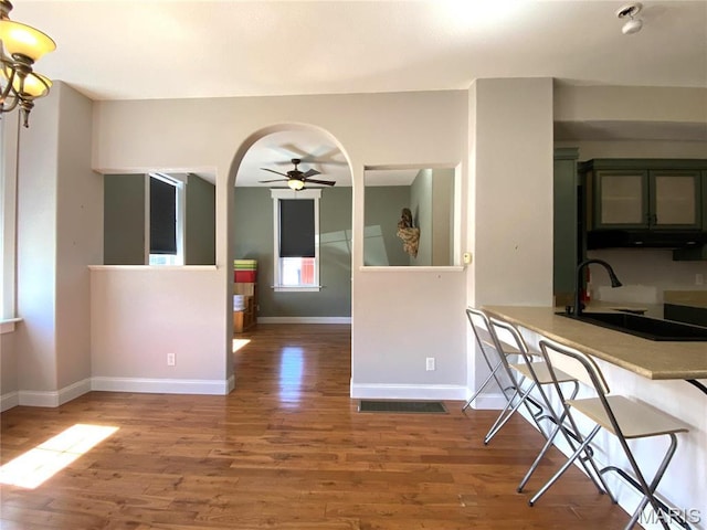 209 E 3rd St, Hermann, MO 65041 - unfurnished dining area with wood finished floors, a ceiling fan, a sink, and baseboards