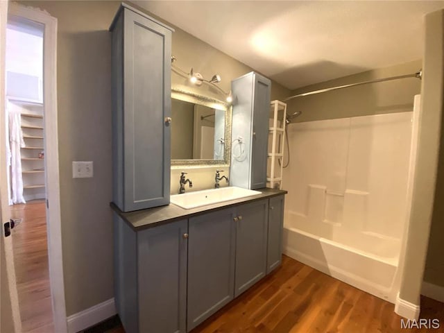 209 E 3rd St, Hermann, MO 65041 - bathroom with wood finished floors, shower / bath combination, vanity, and baseboards
