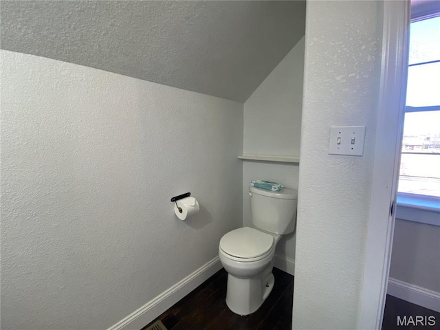 209 E 3rd St, Hermann, MO 65041 - bathroom with vaulted ceiling, baseboards, wood finished floors, toilet, and a textured wall