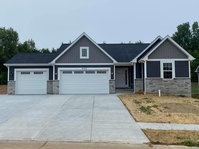 1805 Greg Dr, De Soto, MO 63020 - craftsman-style home with stone siding, an attached garage, concrete driveway, and board and batten siding