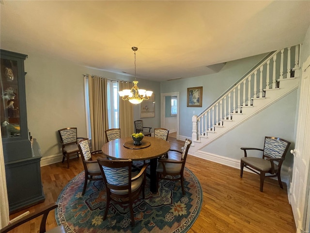 506 E Jefferson St, Perry, MO 63462 - dining space featuring a chandelier, wood finished floors, stairs, and baseboards