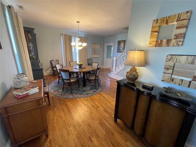 506 E Jefferson St, Perry, MO 63462 - dining space featuring a chandelier, light wood-style floors, stairway, and baseboards