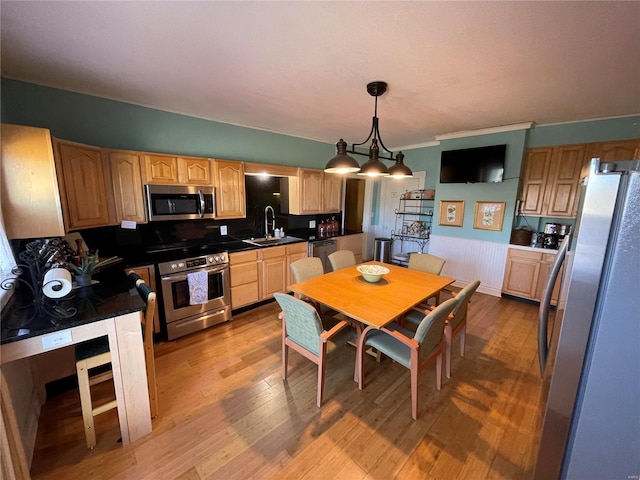 506 E Jefferson St, Perry, MO 63462 - kitchen featuring stainless steel appliances, a wainscoted wall, wood finished floors, a sink, and light brown cabinets