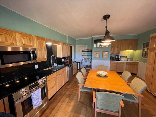 506 E Jefferson St, Perry, MO 63462 - kitchen featuring stainless steel appliances, a sink, wood finished floors, light brown cabinetry, and ornamental molding