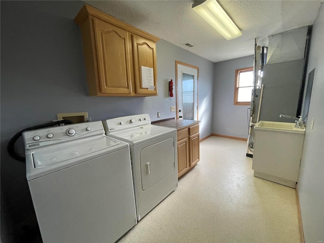 506 E Jefferson St, Perry, MO 63462 - laundry area featuring cabinet space, washing machine and clothes dryer, a textured ceiling, and baseboards