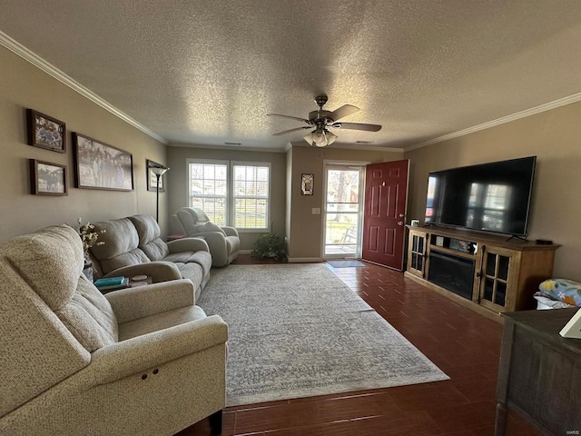 living room with ceiling fan, a textured ceiling, wood finished floors, baseboards, and ornamental molding