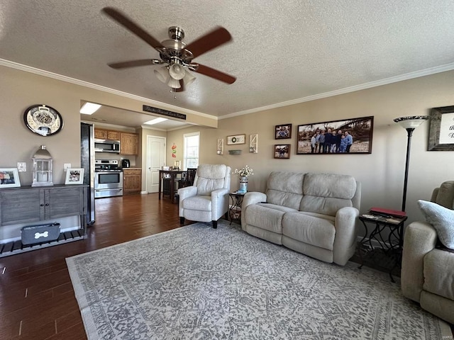 living area with ceiling fan, a textured ceiling, dark wood-style flooring, and ornamental molding